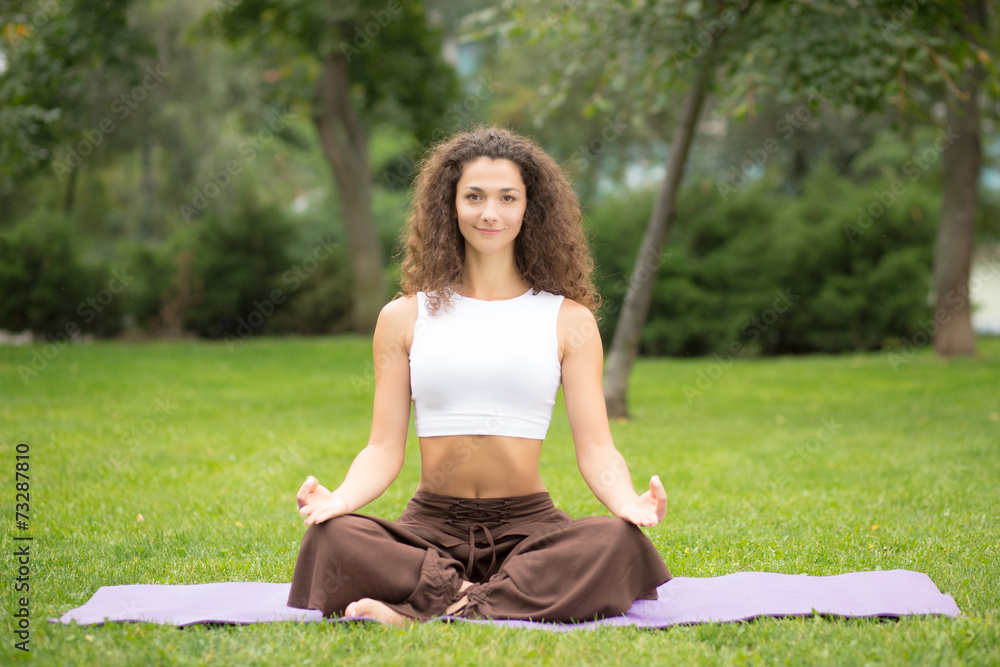 Pretty woman doing yoga exercises