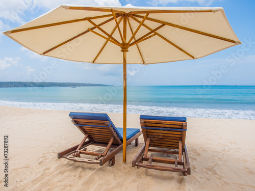 Fototapeta Naklejka Na Ścianę i Meble -  Relaxing couch chairs with parasol on white sandy Beach