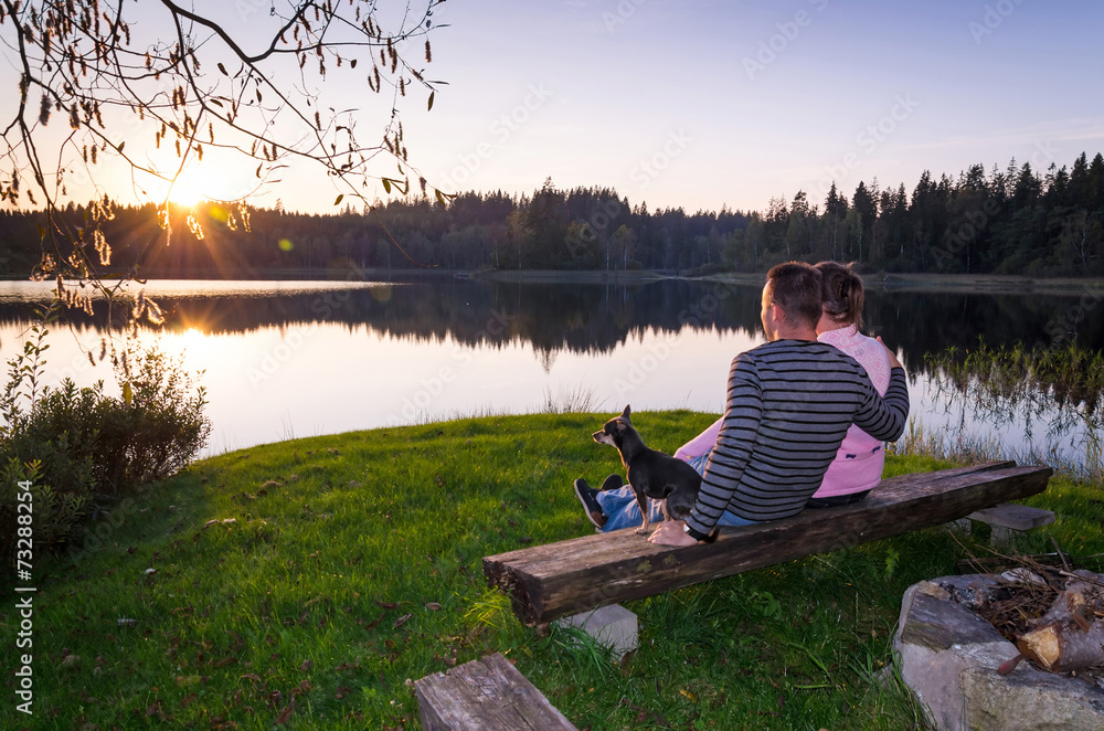 Couple with dog enjoy the late summer sunset Couple with dog enjoy the late summer sunset