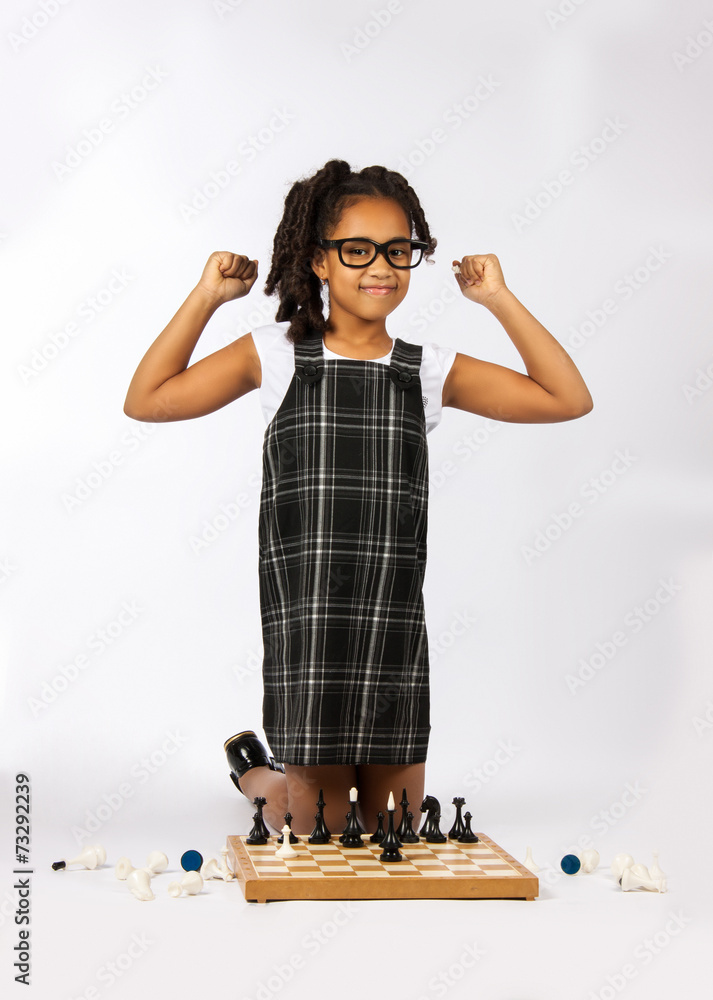 Cute girl playing chess on white