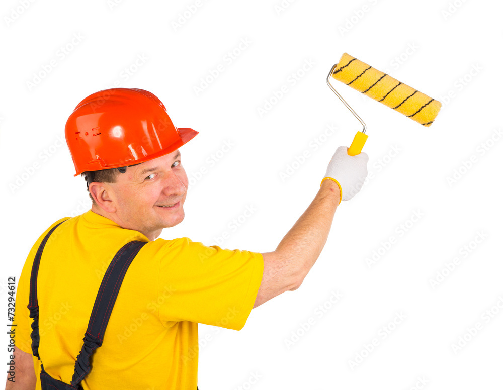 Worker in hardhat paints. Worker in hardhat paints.