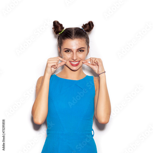Young woman laughing and showing smile by fingers