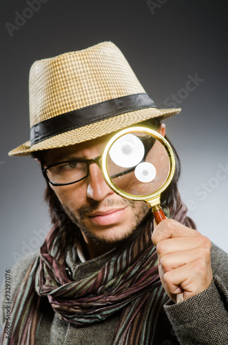 Fototapeta kuchenna Funny detective with smoking pipe and magnifying glass