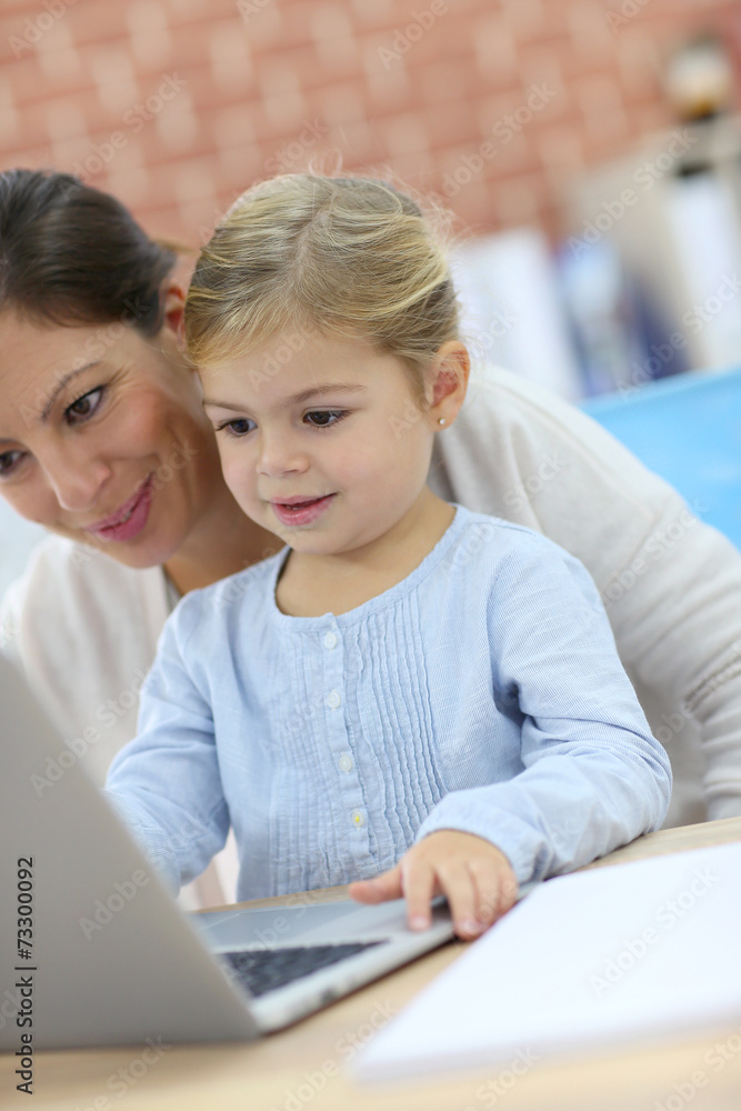 Mother and little girl using laptop computer Mother and little girl using laptop computer