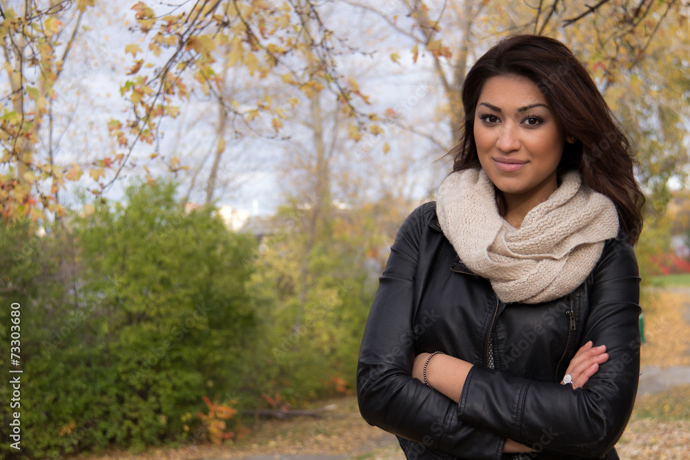 Attractive Hispanic woman posing with arms cross outside during Attractive Hispanic woman posing with arms cross outside during