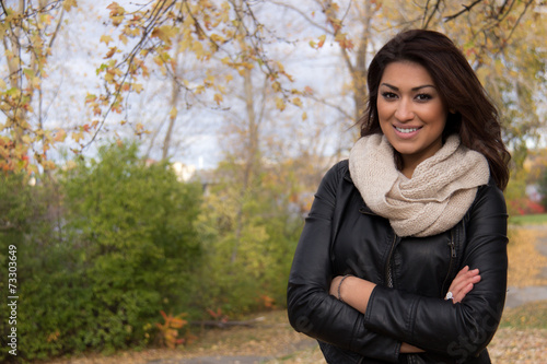 Gorgeous Hispanic woman posing with arms cross outside during au