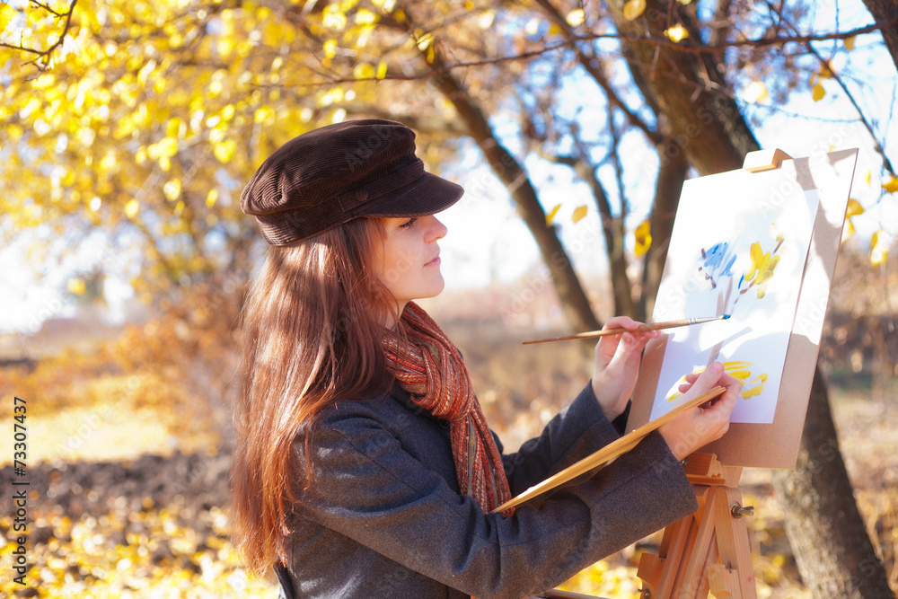 Naklejka premium The girl is engaged in painting