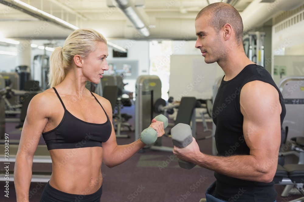 Naklejka premium Strong couple lifting hand weights together