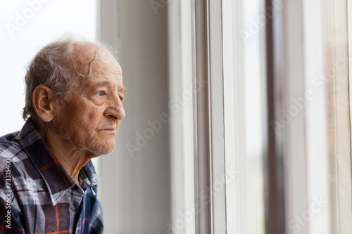 Foto Portrait of Elderly man looking out window