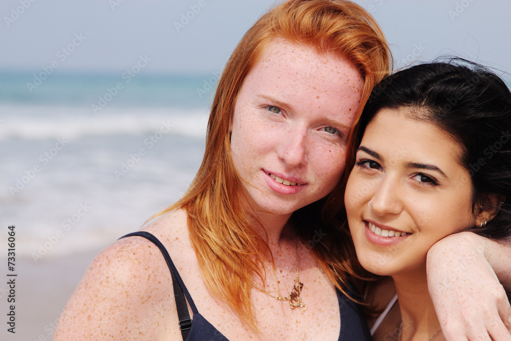 two smiling young teenage girlfriends on the beach two smiling young teenage girlfriends on the beach