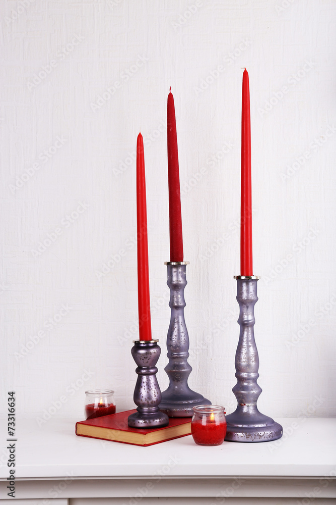 Candles in candle holders, vase and book