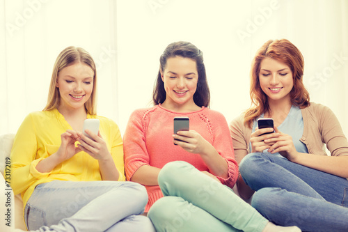 smiling teenage girls with smartphones at home © Syda Productions