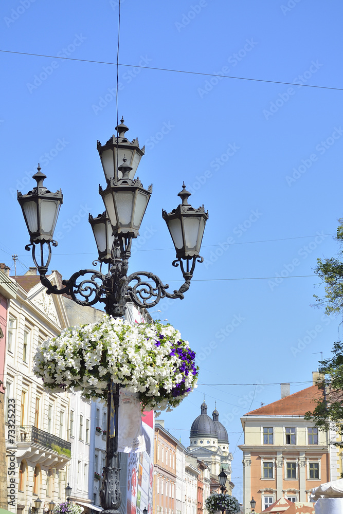 forged lamppost with old town background