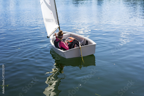 Young Girl sails on the lake on a beautiful sunny day photo