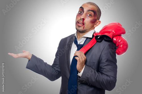 Fotografie Badly beaten businessman with boxing gloves