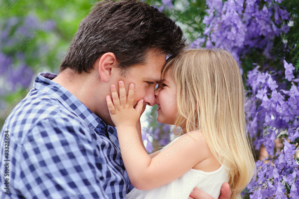 Young father and his cute daughter love in blooming garden Young father and his cute daughter love in blooming garden