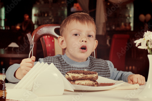 Cute little boy about to tuck into a slice of cake