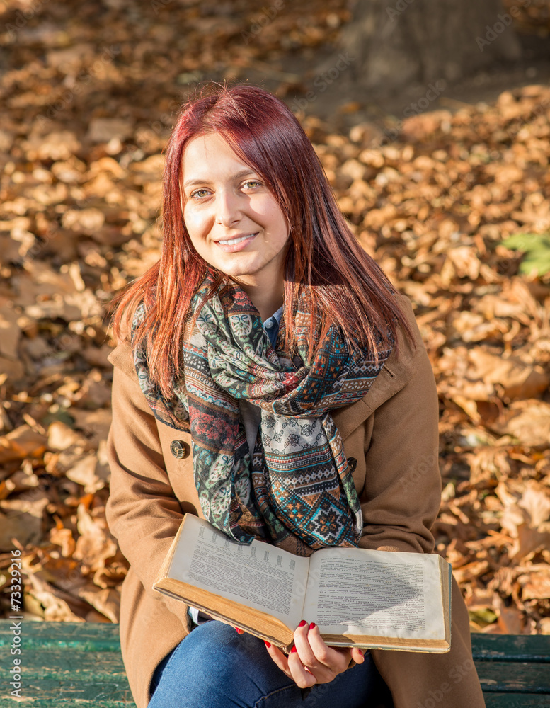 Happy girl sitting on bench in park Happy girl sitting on bench in park