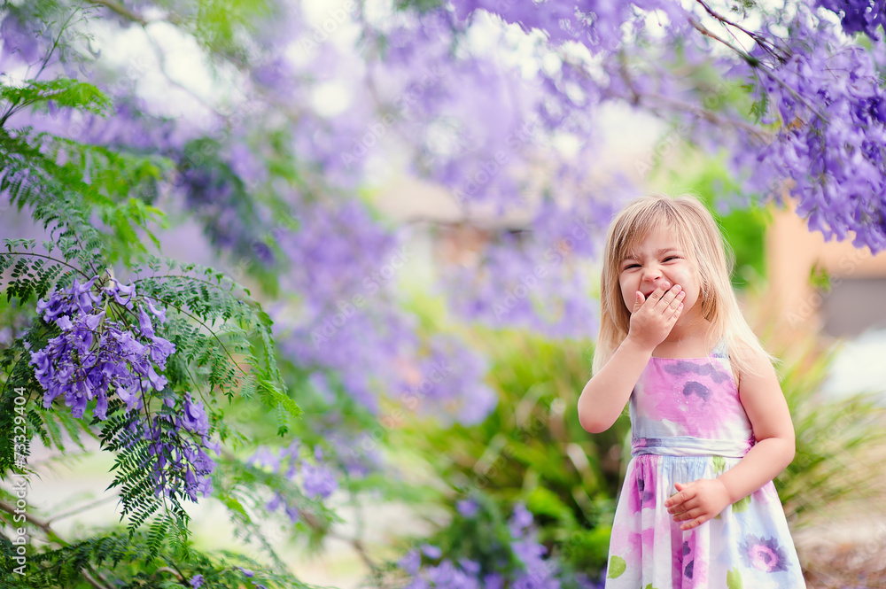 Cute happy little girl in blooming park. Beautiful Jacaranda Cute happy little girl in blooming park. Beautiful Jacaranda