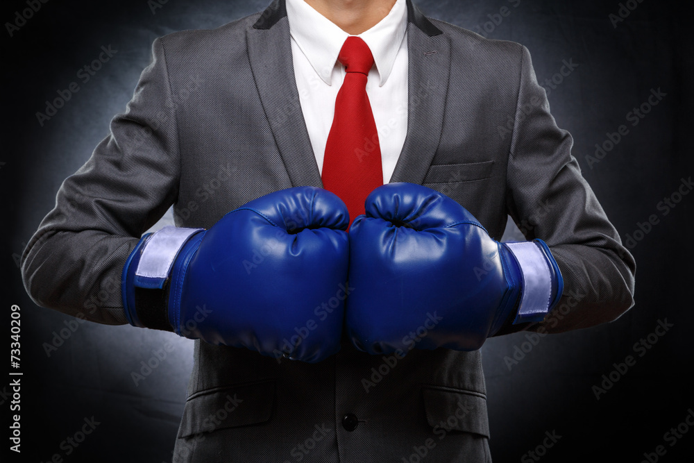 Business man in blue gloves on dark background