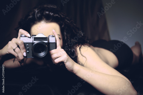 Pretty brunette in a retro style takes a photo photo