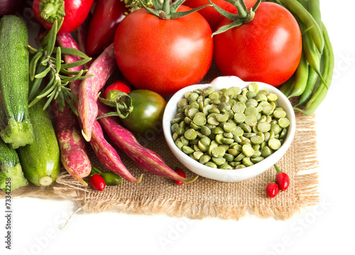 Green peas in and vegetables on a white background