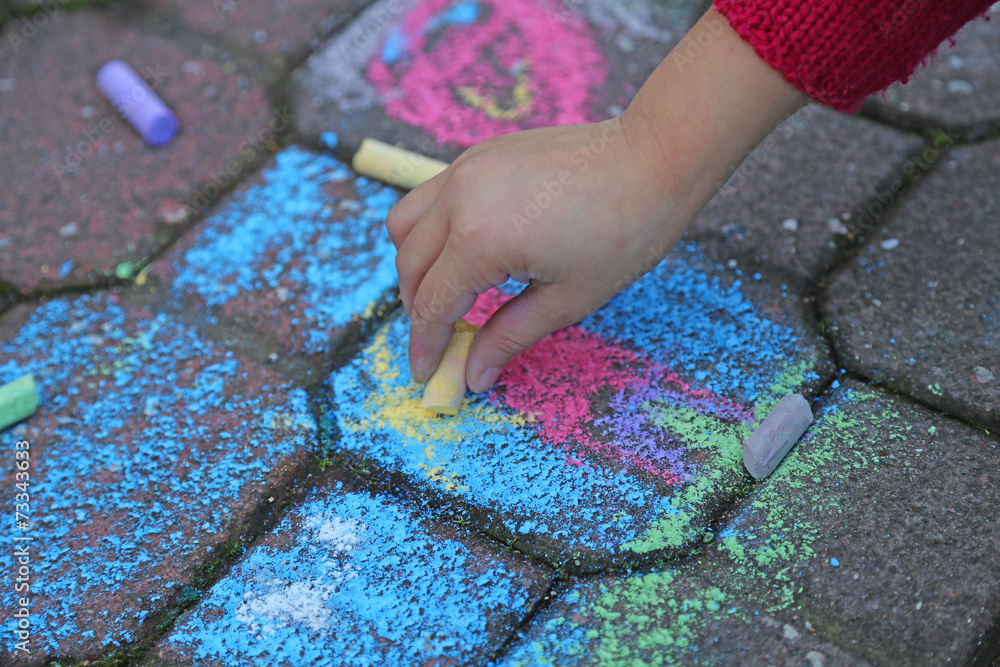 young girl draws with the colourful chalks young girl draws with the colourful chalks