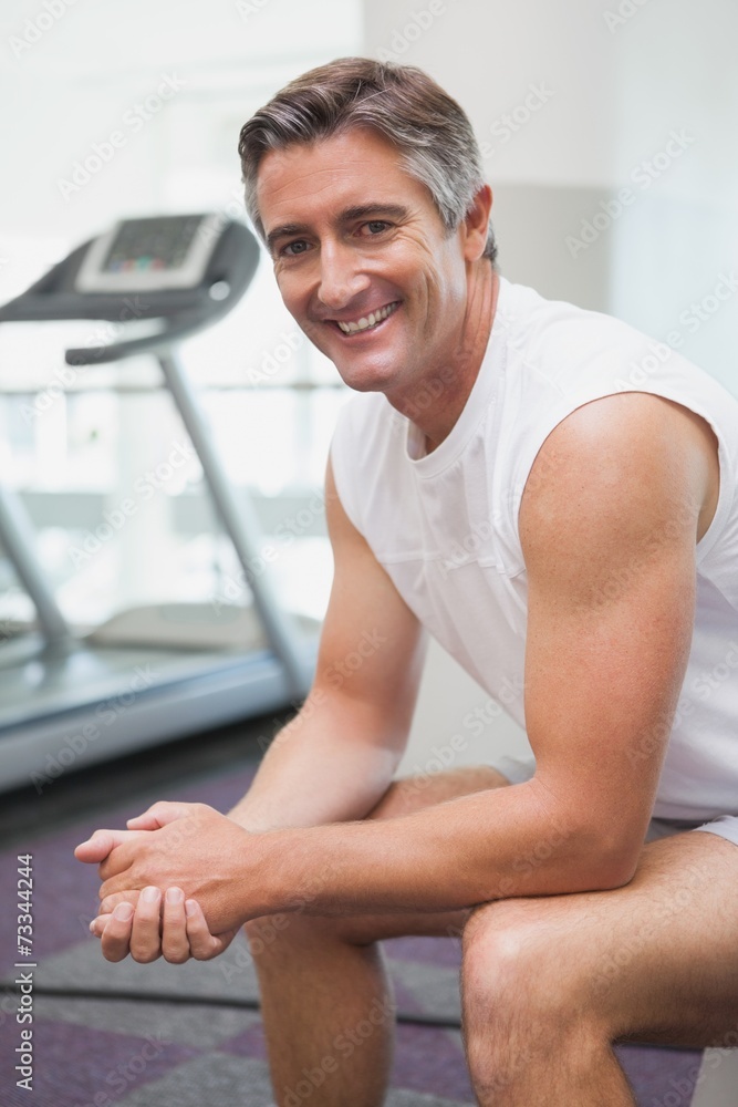 Fit man smiling at camera in fitness studio Fit man smiling at camera in fitness studio