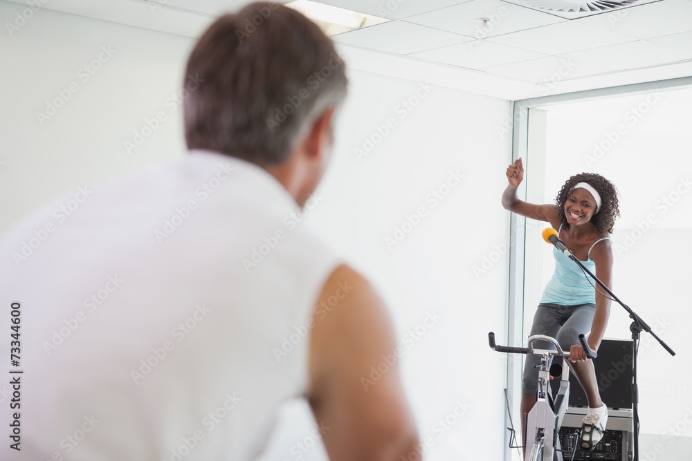 Spinning instructor motivating her class Spinning instructor motivating her class
