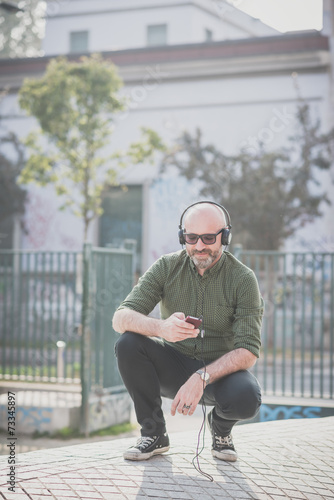 Smiling mature man listening to music outdoors