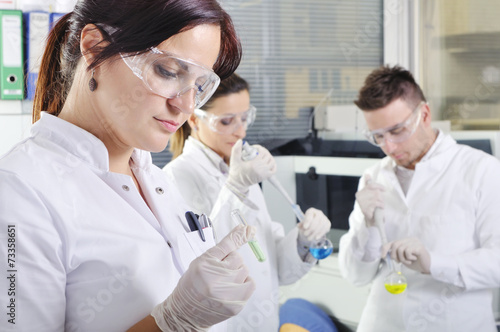 Attractive young PhD students scientists observing in the labora