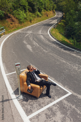 businessman sitting on armchair in the middle of the road © alexandre zveiger