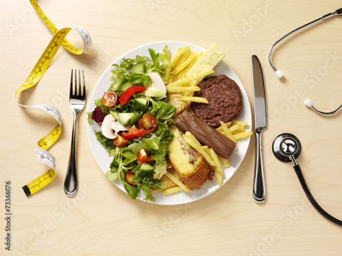 Plate of unhealthy food and salad for a healthy lifestyle