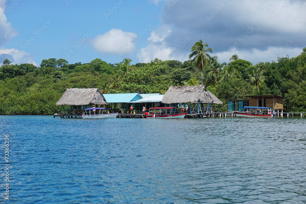 Tropical restaurant over the sea with boat at dock