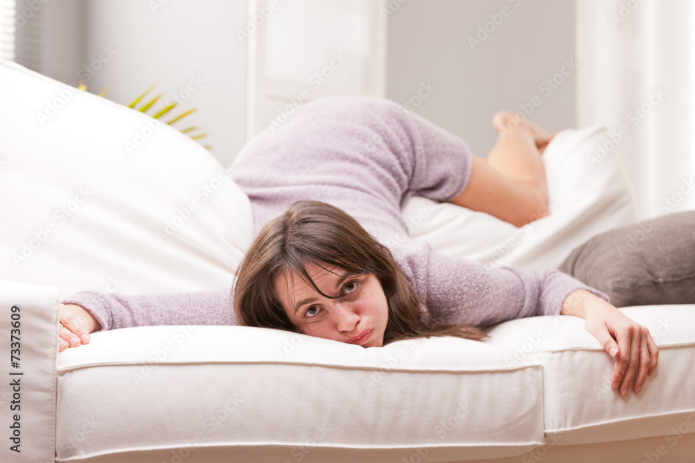 funny girl showing fatigue on a sofa funny girl showing fatigue on a sofa