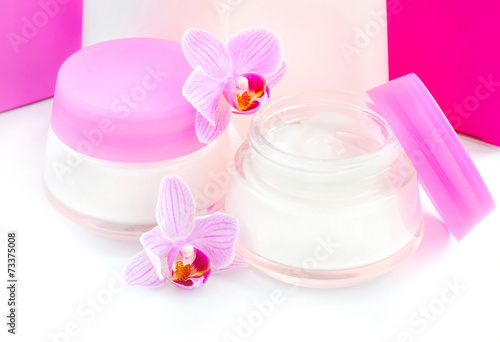 Face creams and beautiful orchid flowers on white background