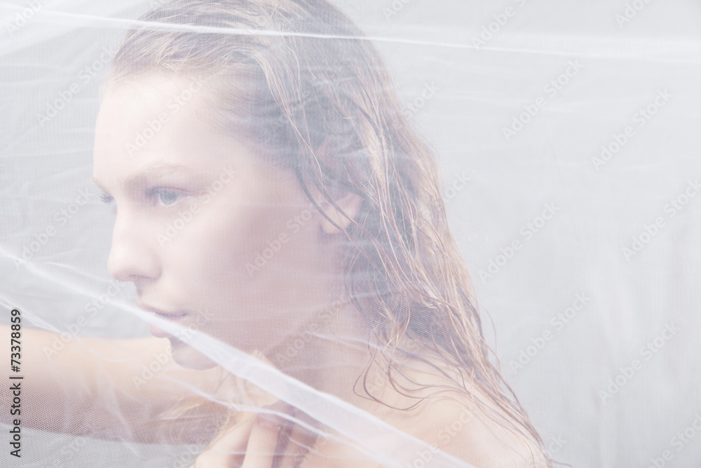 Beautiful wet woman face with waving fabric