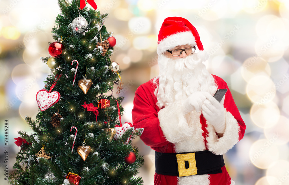 santa claus with smartphone and christmas tree santa claus with smartphone and christmas tree