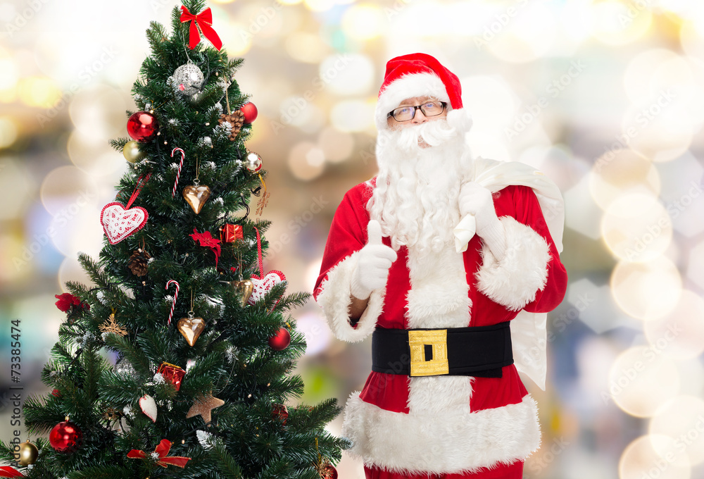 santa claus with bag and christmas tree