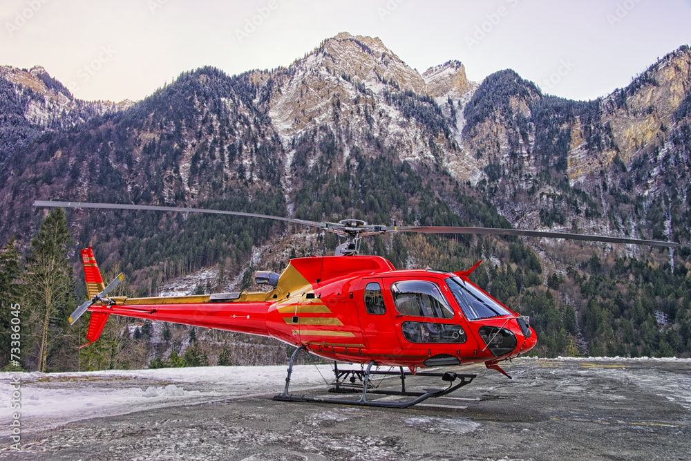 Fototapeta premium Red helicopter in heliport at swiss alps