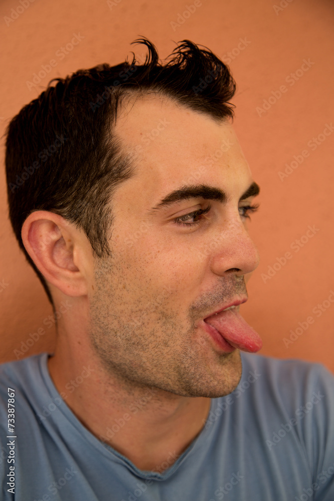 Fototapeta premium Male model silly expression sticking out his tongue