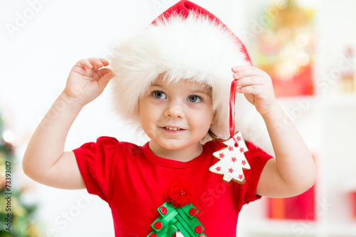 child girl in Santa hat hol...