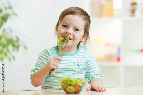 kid girl eating healthy veg...