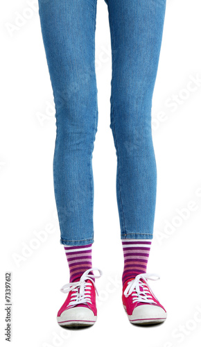 Female legs in colorful socks and sneakers isolated on white