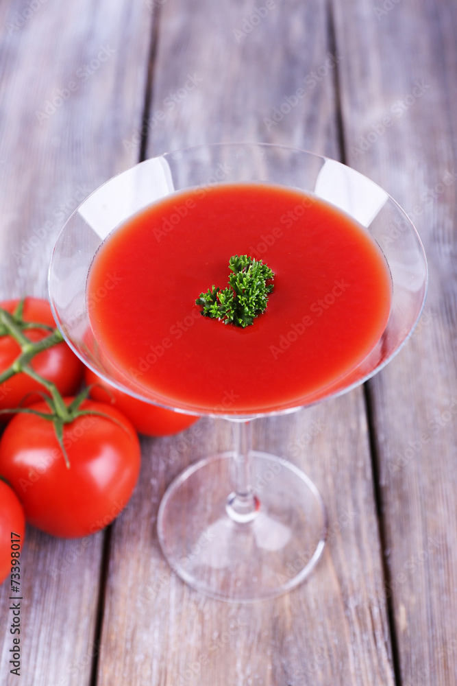 Tomato juice in goblet and fresh tomatoes on wooden background Tomato juice in goblet and fresh tomatoes on wooden background
