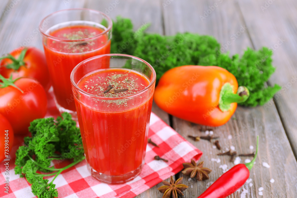 Tomato juice in glasses and fresh vegetables Tomato juice in glasses and fresh vegetables