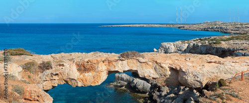 Panoramic view of a natural rock bridge at sea coast