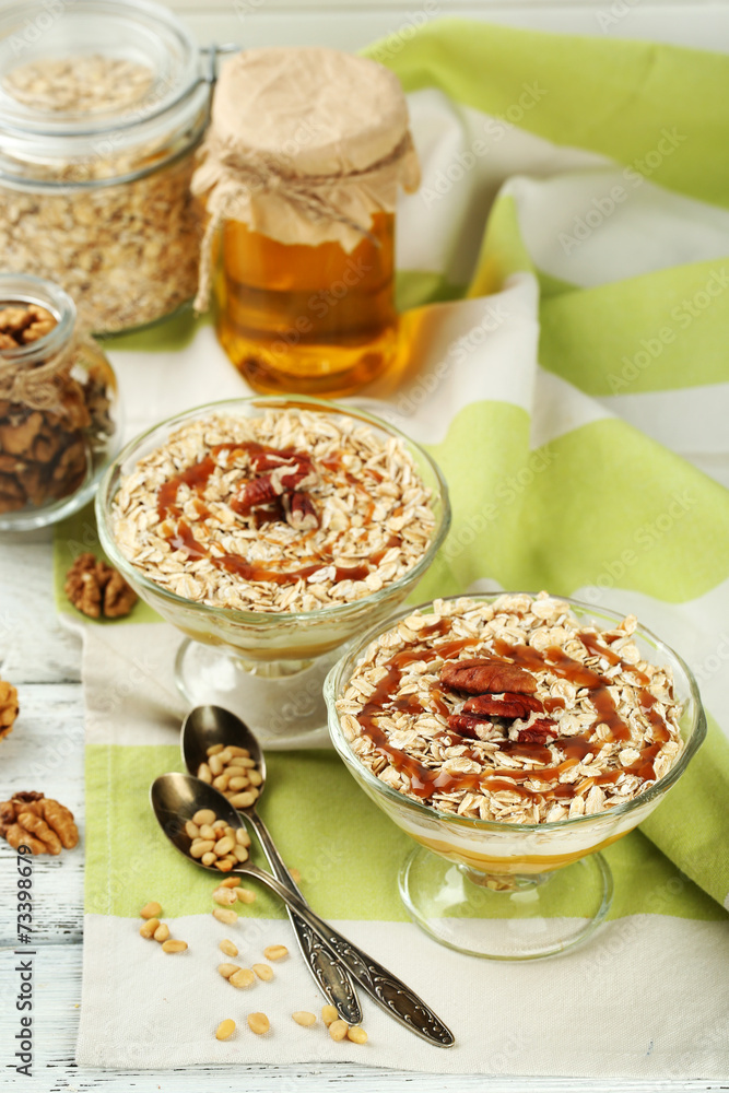 Tasty dessert with oat flakes and honey, on table Tasty dessert with oat flakes and honey, on table