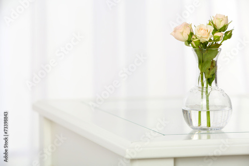 Beautiful bouquet of flowers in vase on window background