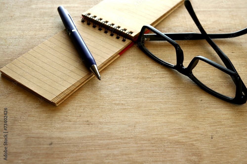 Notebook, pen and eyeglasses